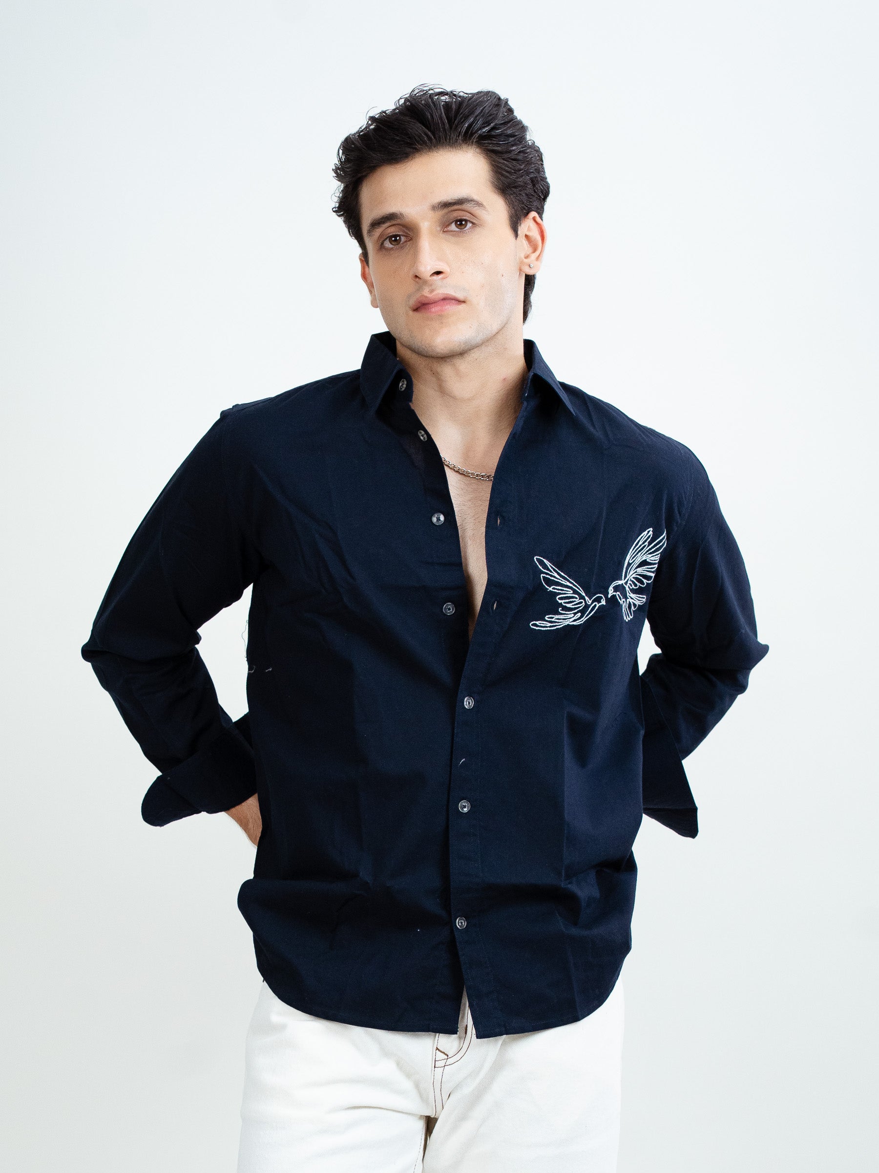 Man wearing navy blue embroidered shirt, styled for casual dates