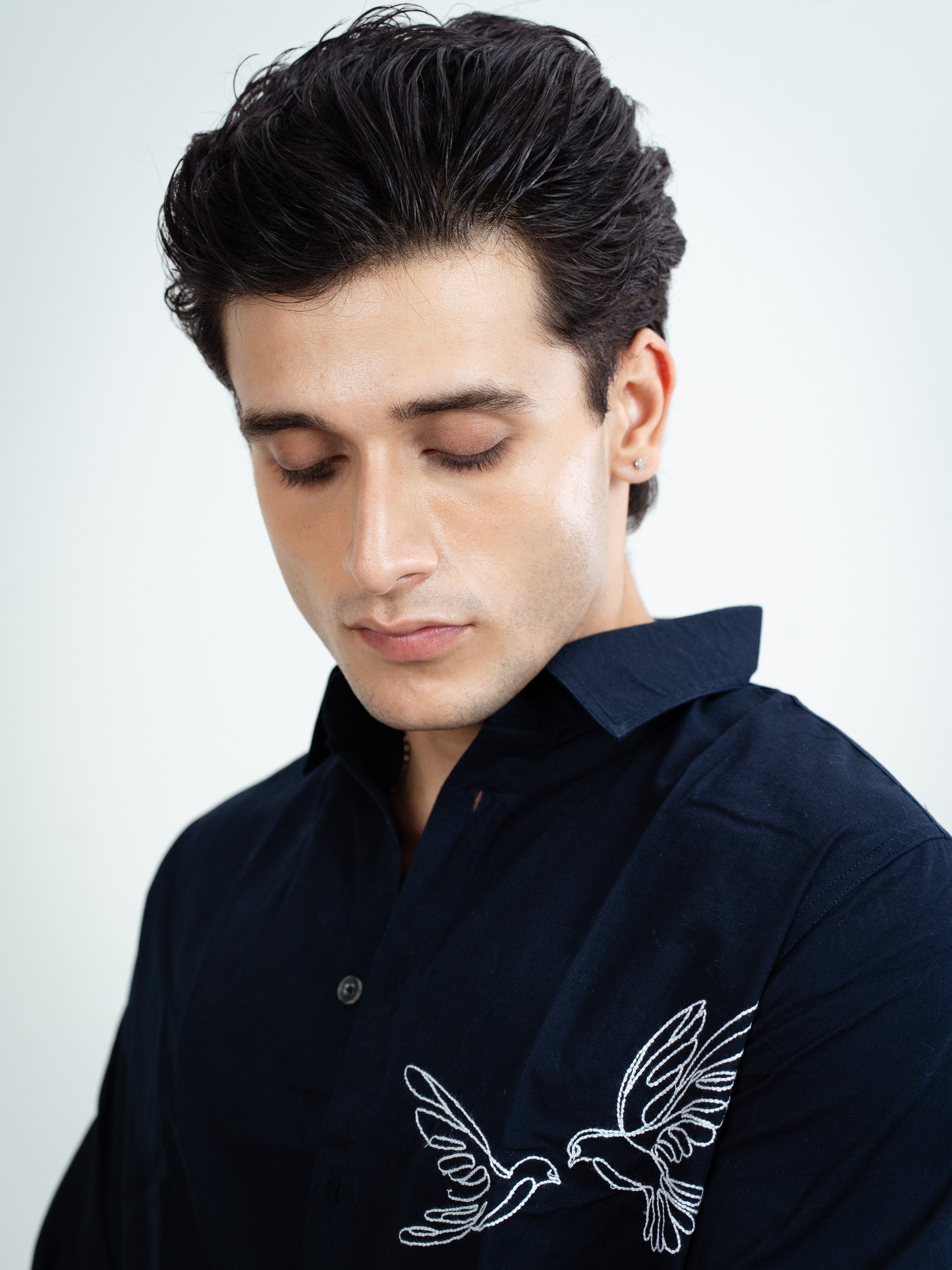 Close-up of intricate embroidery on navy blue inen shirt